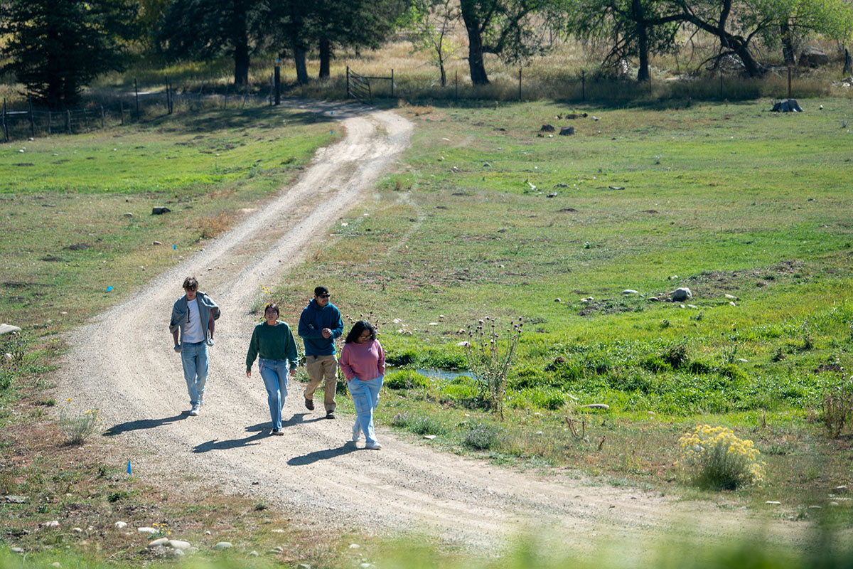 Students walk together on a gravel road at the Old Fort.